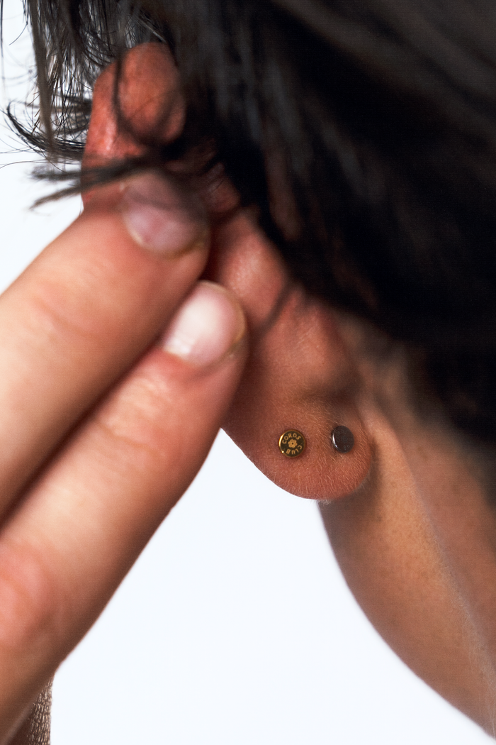 Close up of the back of someone's ear, showing how minimal and sleek that threadless labret flat back studs look.
