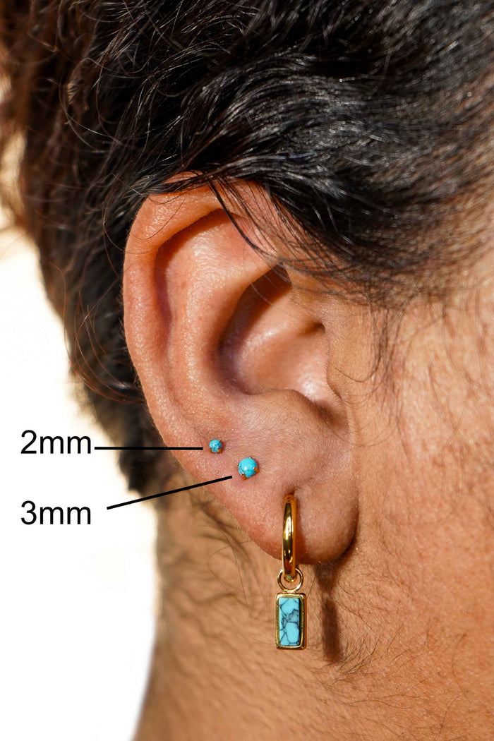 Close-up of an ear with a turquoise earring, showing sizes 2mm and 3mm.