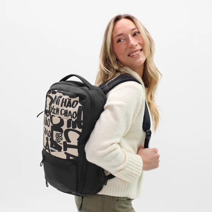 A woman wearing a Sherpani Camden Ciao Ultimate Backpack on her back against white background.  #color_ciao-print