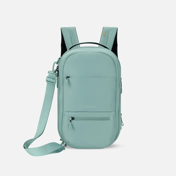 A Sherpani Camden Surf Blue Ultimate Backpack, front view showing various pockets and strap options on white backdrop.  #color_surf-blue