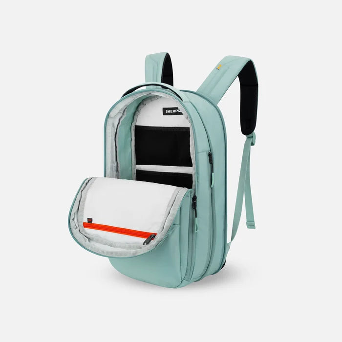 A Sherpani Camden Surf Blue Ultimate Backpack, 3/4 view showing inside of main pocket on a white background.   #color_surf-blue
