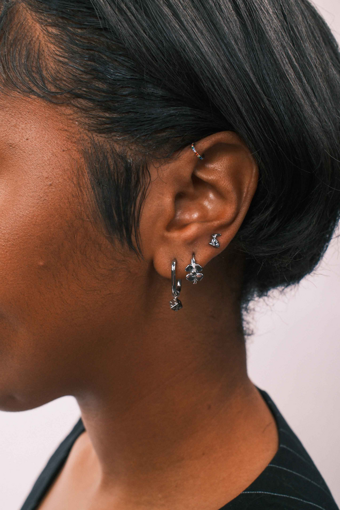 Close-up of an ear with earrings against a neutral background