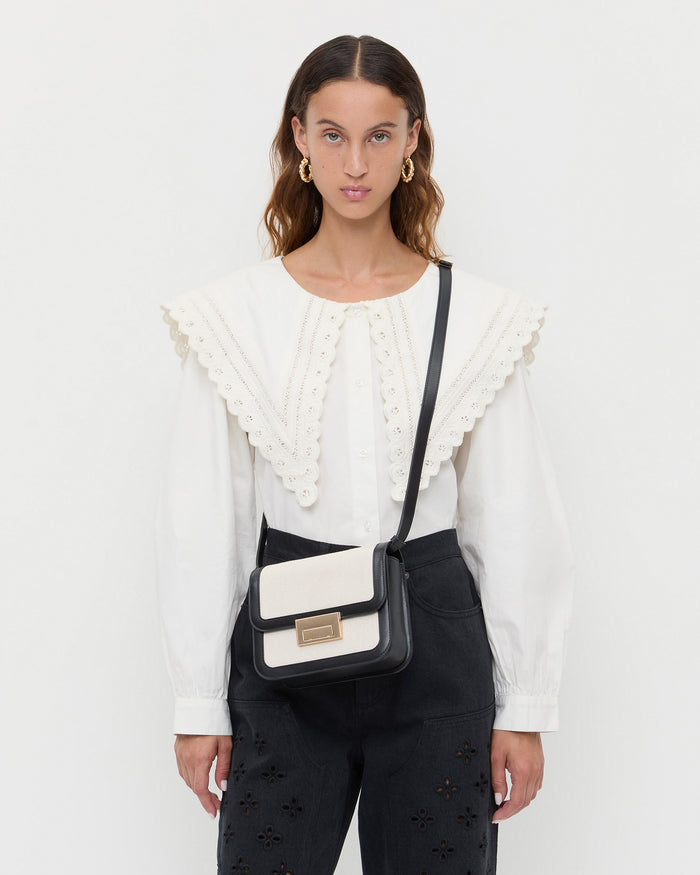 Desi Black/Natural Canvas Crossbody in natural canvas with black leather accents, Ken Shirt in white cotton, and Demi Embroidered Pant in black denim.