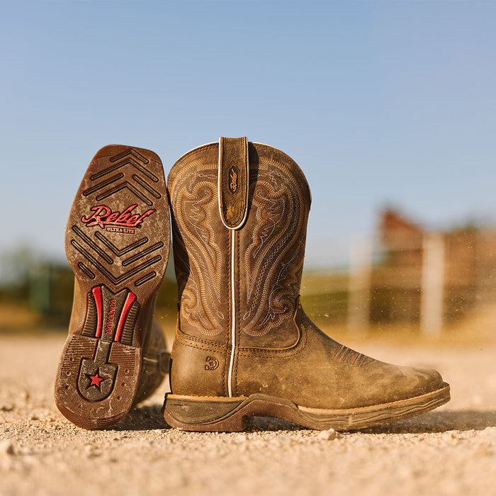 Women's Durango Rebel Ultra lite western boot in Texas on a gravel road with outsole showing