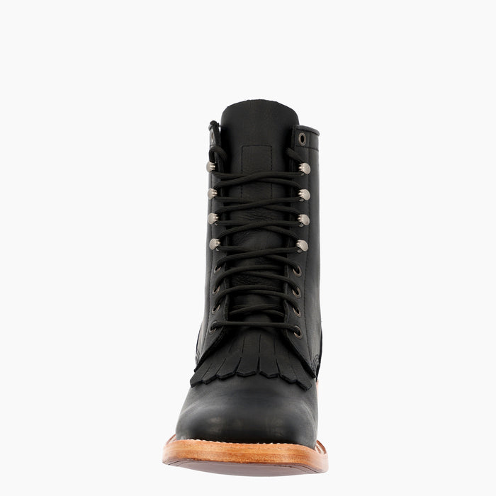 A single black leather lace-up boot with fringe detailing and silver metal eyelets, shown from a front-facing perspective on a light gray background.