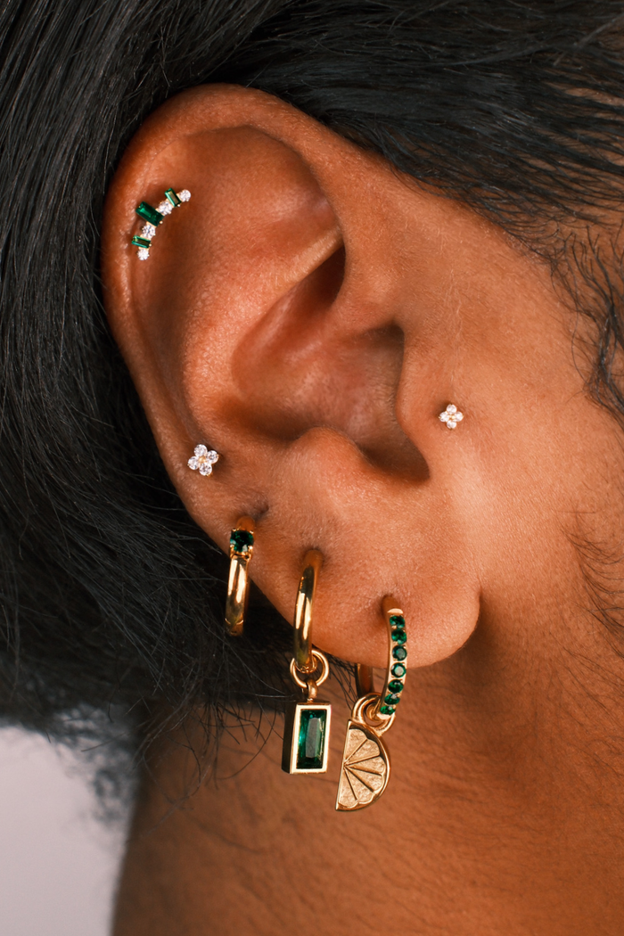 Close up of an ear with multiple earrings