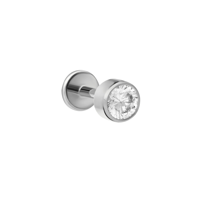 Close up of push-pin style flat back stud made from ASTM F136 Implant Grade Titanium. The flat back stud design is a bezel-set round zirconia stone, clear in color.