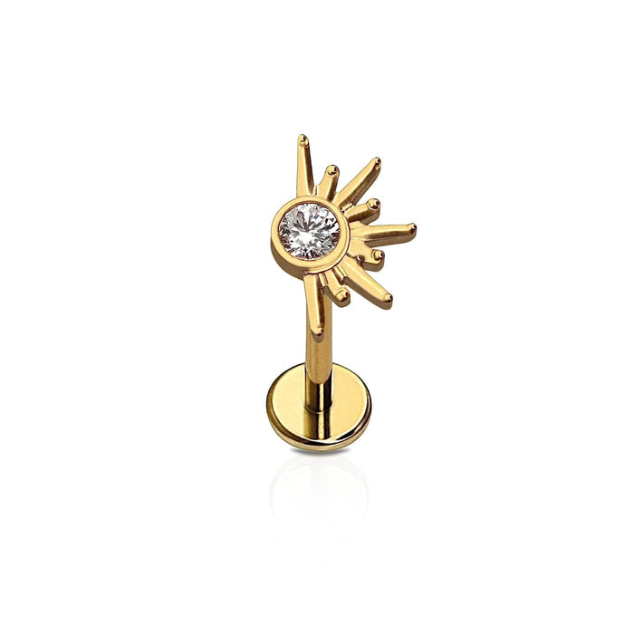 Gold sun-shaped earring with a central gemstone on a white background