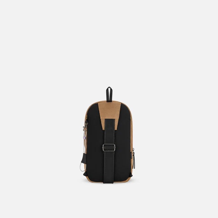 A Sherpani Metro Sand Anti-theft Reversible Sling, back view showing adjustable strap and chair lock on white background. #color_sand-tan