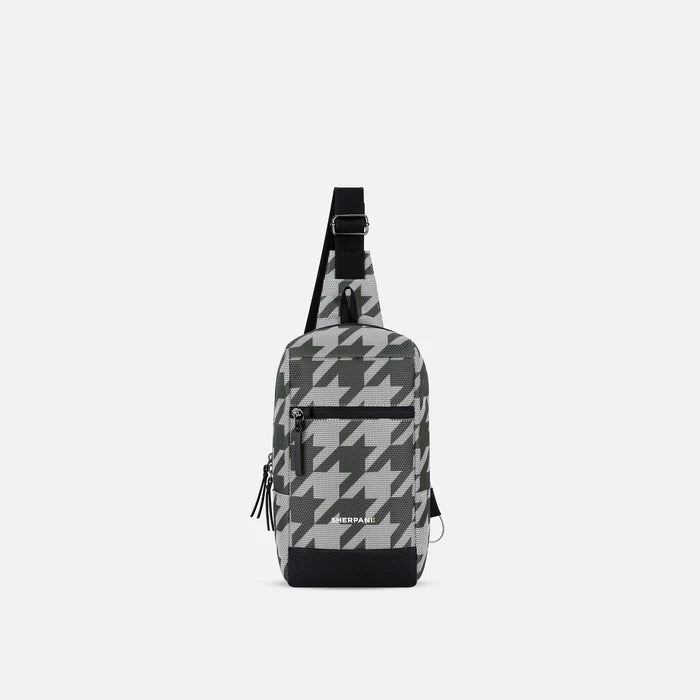 A Sherpani Metro Houndstooth Anti-theft Reversible Sling, front view showing lockable pocket and main strap on white background. #color_houndstooth-print