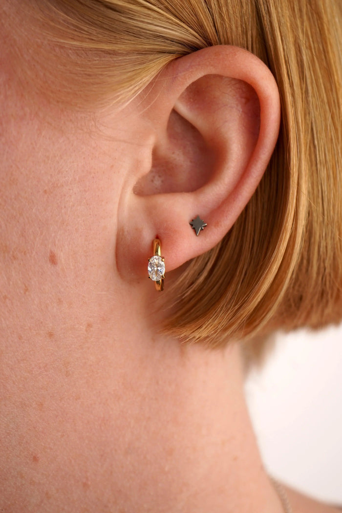 Close-up of a person's ear wearing two earrings.