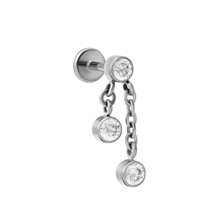 Close up of push-pin style flat back stud made from ASTM F136 Implant Grade Titanium. The flat back stud design is a bezel-set round zirconia stone, clear in color. 2 additional stones of the same color and design dangle off of 2 chains, one short, one long, that hang from the main stone.