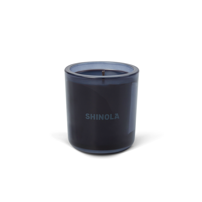 The Shinola Rhythm 8 oz Scented Candle features a dark blue recycled glass holder with "SHINOLA" on the front and a blue coconut soy single-wick candle, displayed against a plain white background.