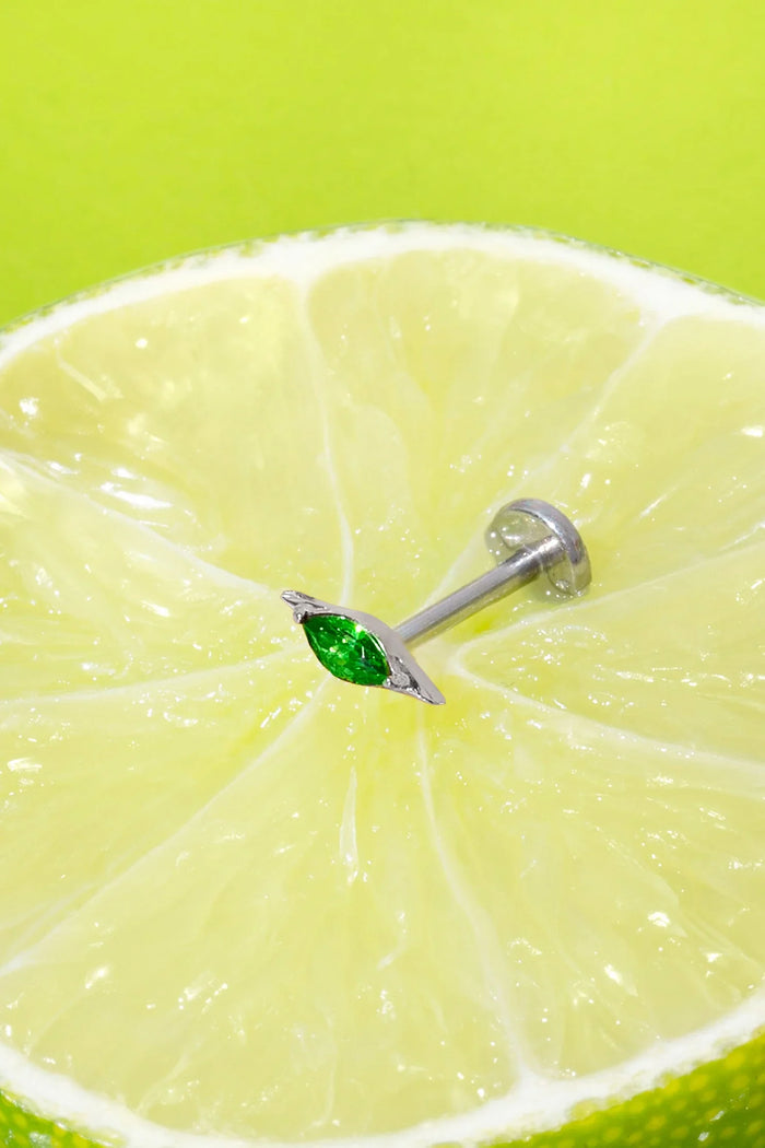 Lime wedge with a silver flat back stud earring featuring a green marquise gemstone on a green background