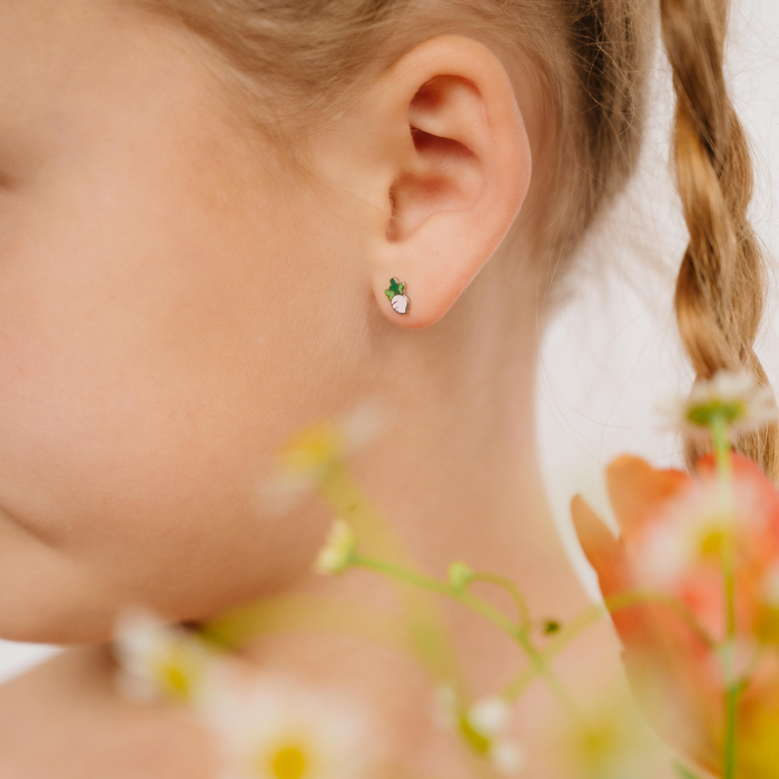 A close up of a turnip shaped flat back stud with blush pink enamel and titanium metal.