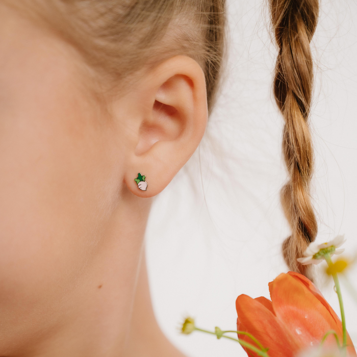 A close up of a turnip shaped flat back stud with blush pink enamel and titanium metal.