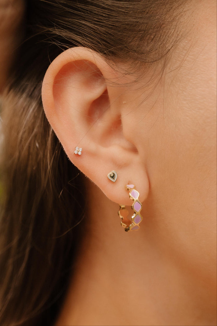 Close-up of a person wearing earrings with a blurred natural background